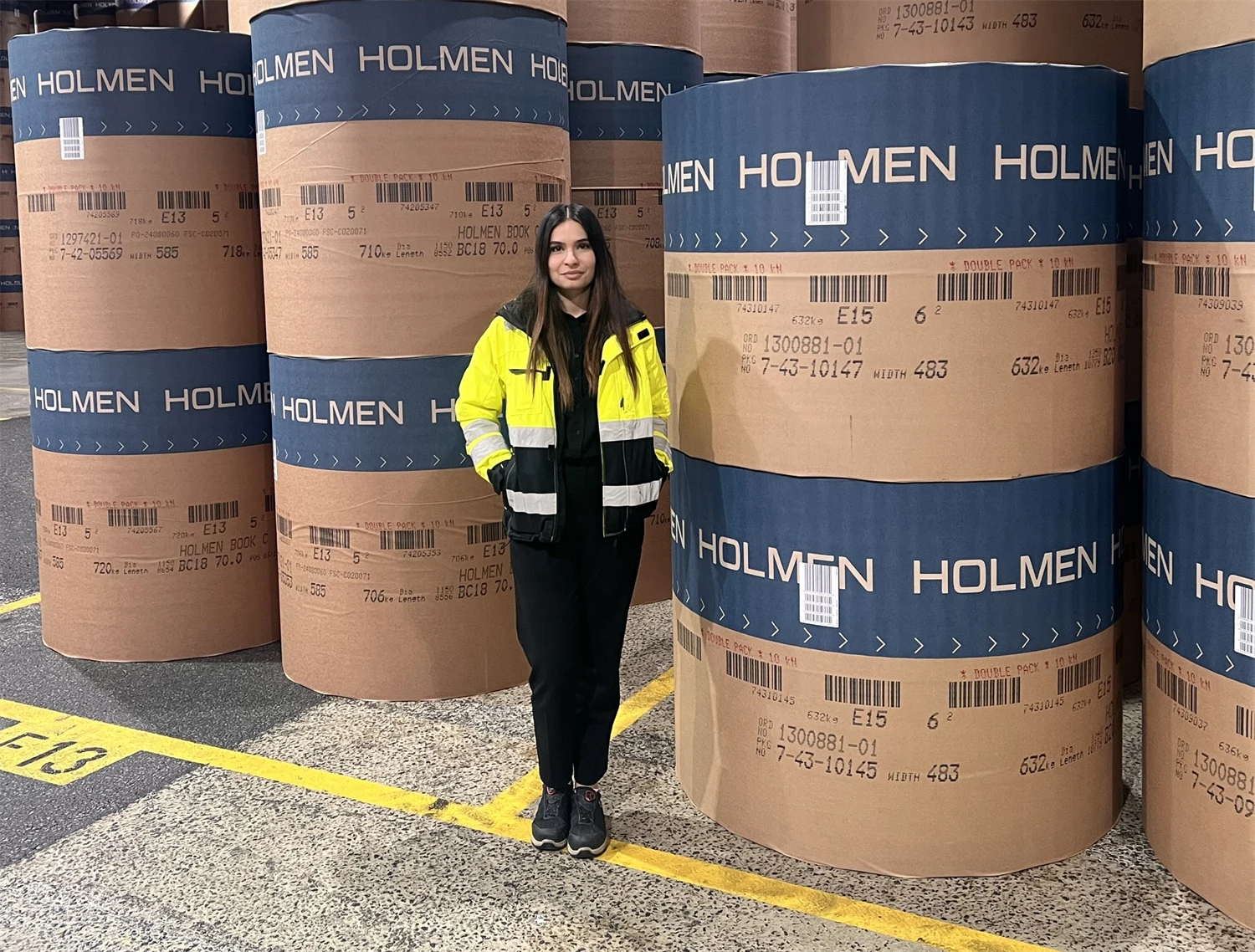 Bild på Sarina framför paketerade pappersrullar