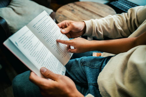 Child and grown-up reading book together