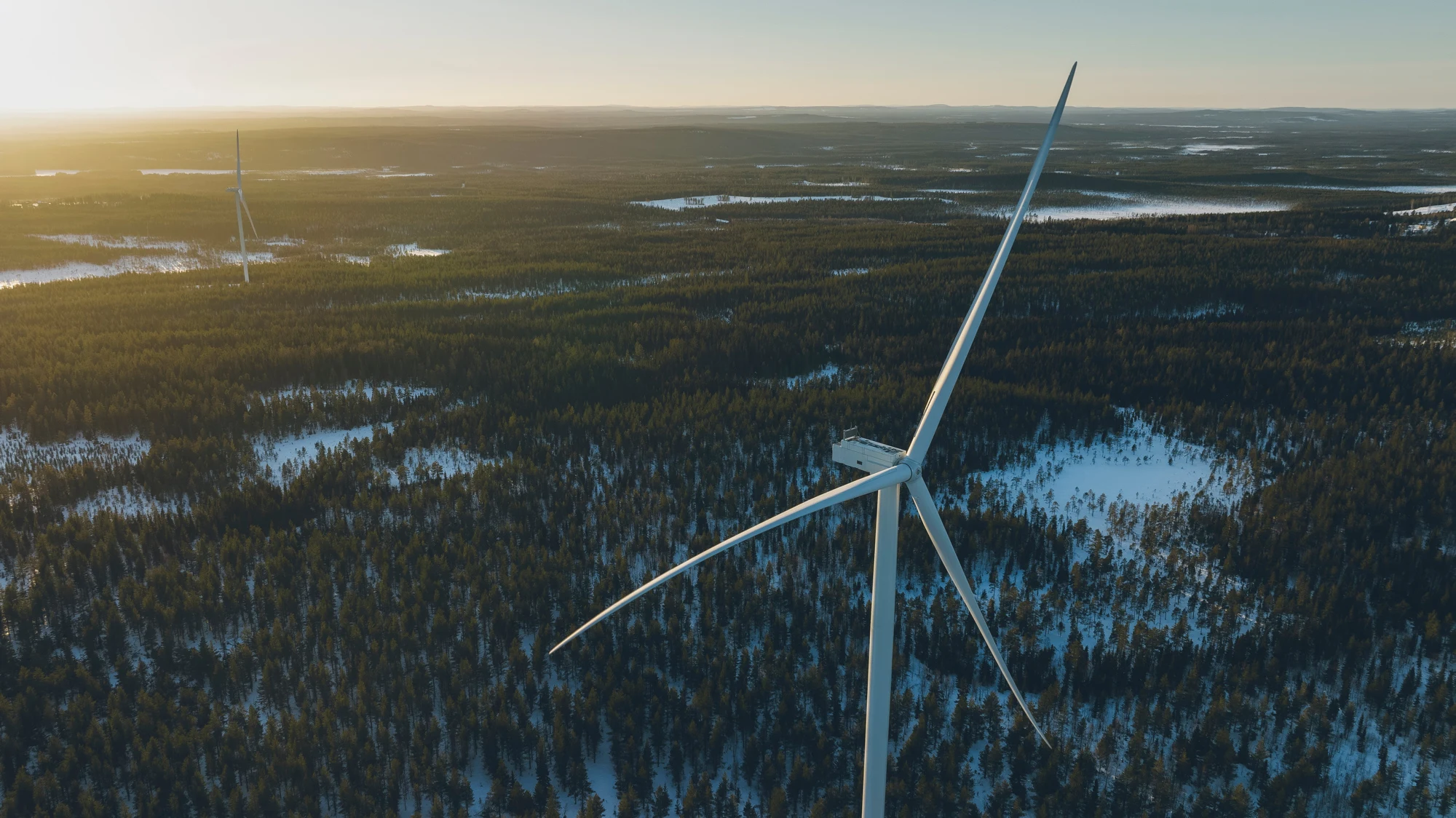 Vindkraftspark med centrerat vindkraftverk sett från ovan.