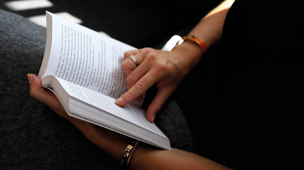 Reading in a book printed on paper