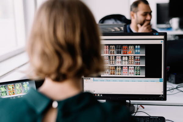 View from behind of a woman at her computer working on graphics