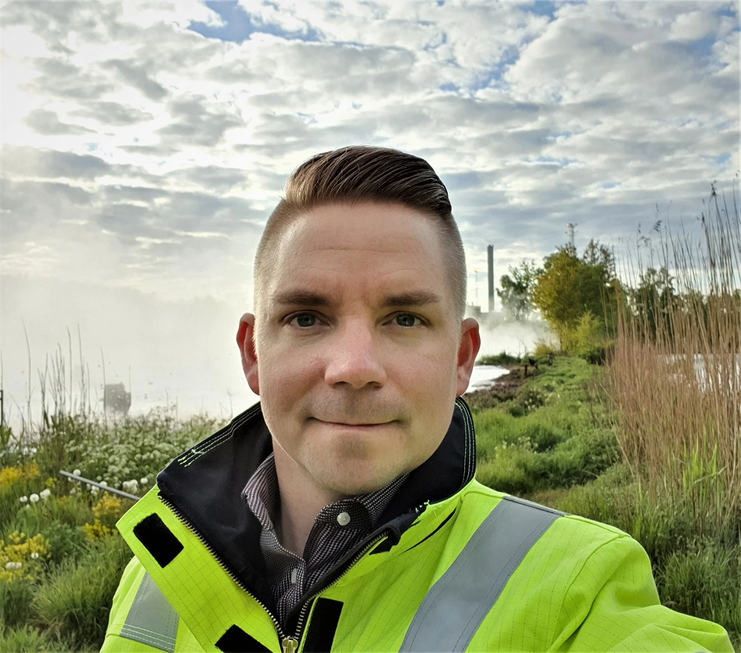 Henrik i varselkläder med himmel och gräs i bakgrunden