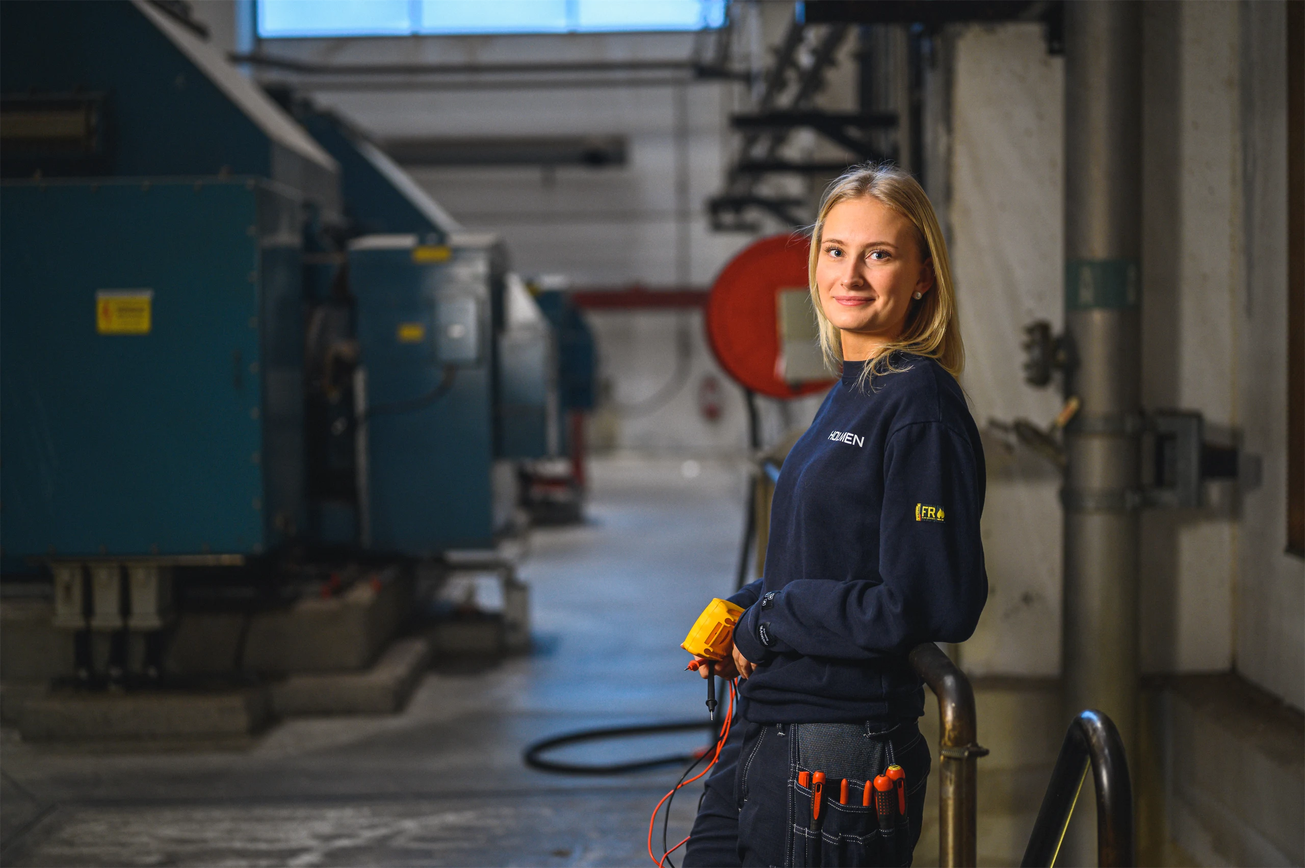 An employee is standing inside one of Holmen's mills, surrounded by industrial equipment.