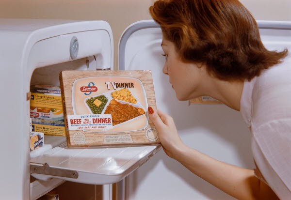 Woman takin out pre-packaged food from old school freezer