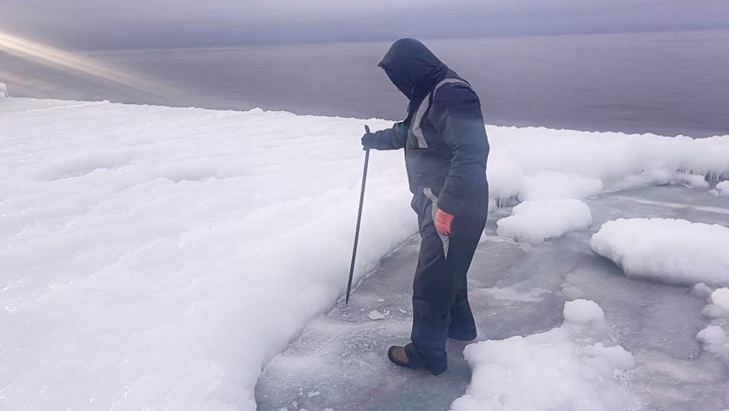 A crew member chips ice off the cargo on board.