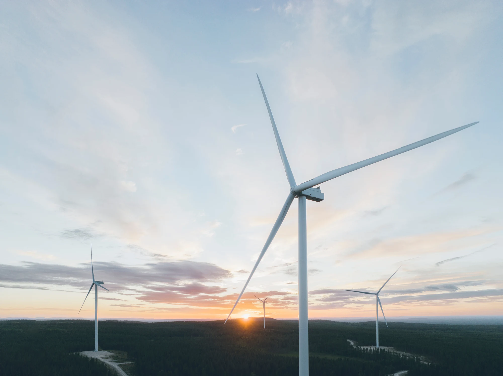 Vindkraftverk mot blå himmel sett underifrån.