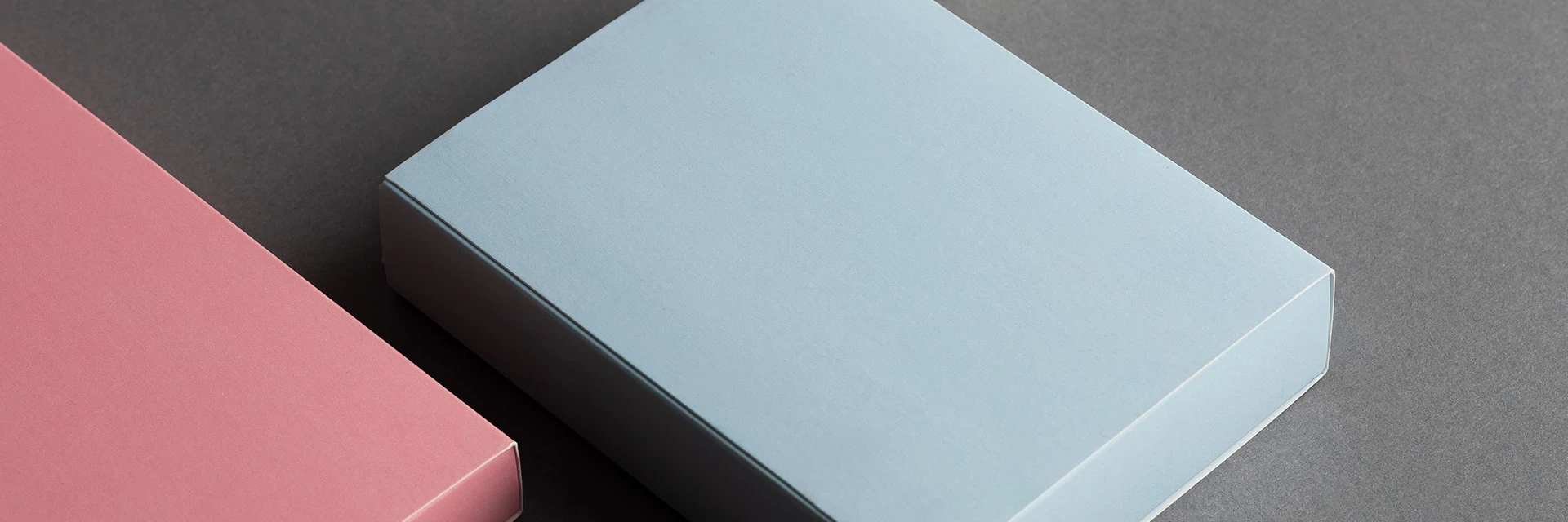 Paperboard boxes in different colors on dark background 