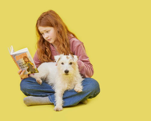 Girl reading a book with dog